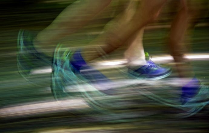 Image shows blurred feet in sneakers running