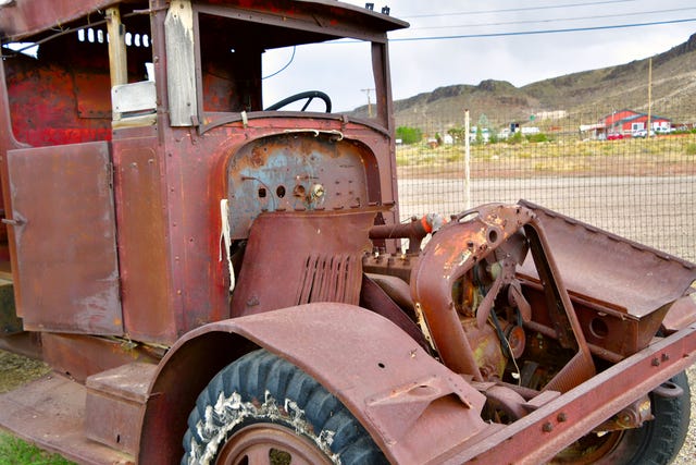 Junk truck, very rusty and stripped down to the skeleton.