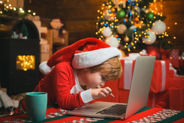 kid typing in Santa Hat