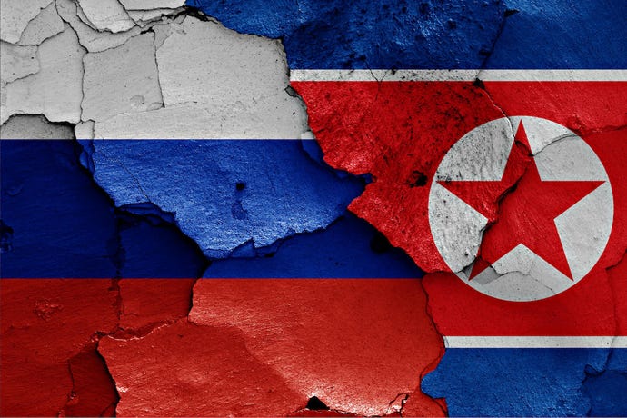 image of cracked North Korean and Russian flags joined together.