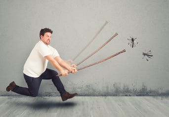 man with flyswatter attempting to swat bugs