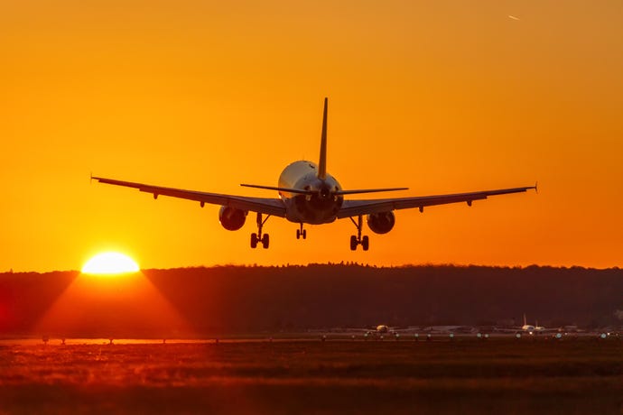 An airplane landing at sunset