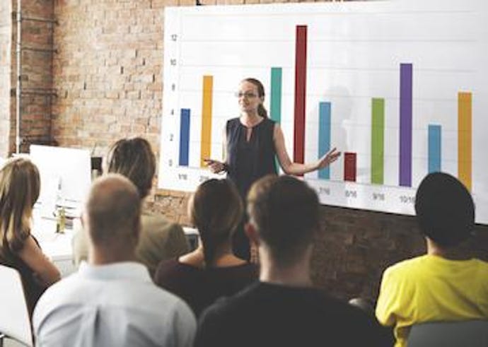 Speaker presenting data chart to an audience.