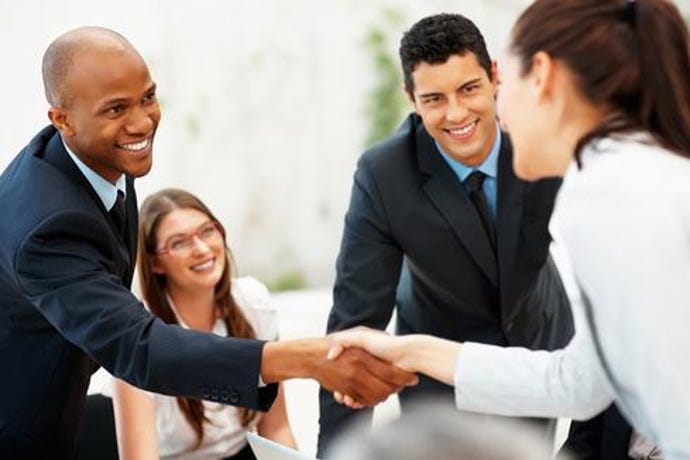 Four businesspeople of various ethnicities and genders greet each other with handshakes.