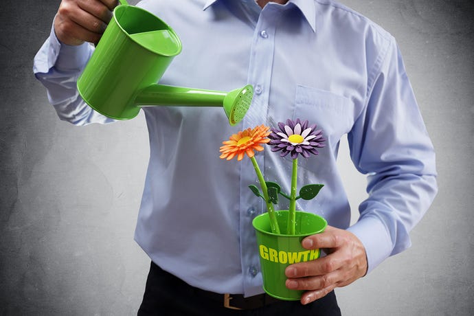 Photo of a man holding a potted plant labeled "growth" and watering it with a watering can. His head is cropped out