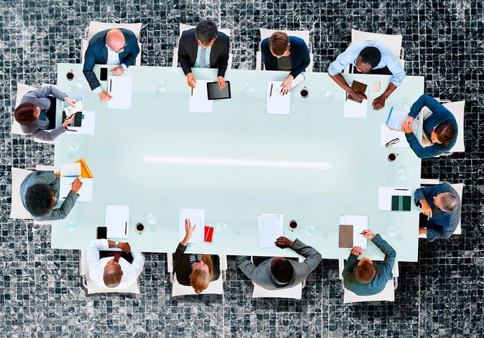 Overhead photo of a bunch of businesspeople sitting around a large conference table