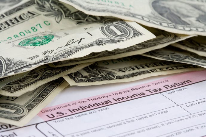tax forms and a stack of cash