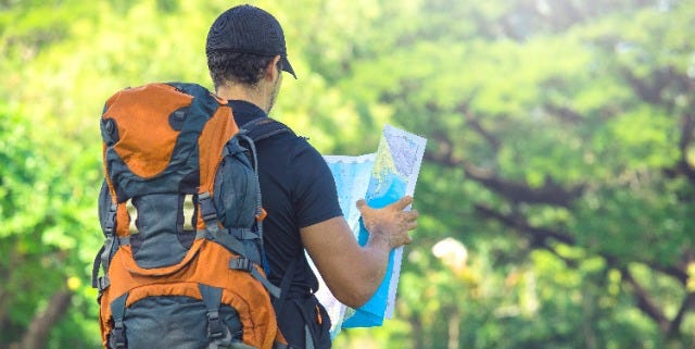 Backpacker in nature looking at a map