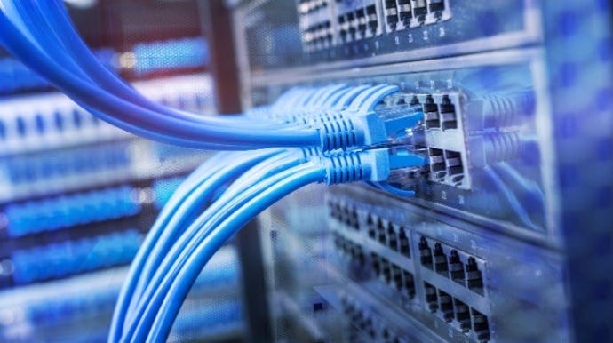 multiple blue Ethernet cables being plugged into a network device.