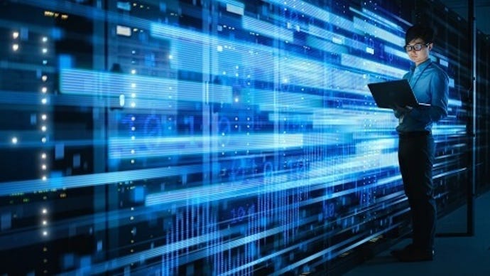 Man standing in a data center, glowing blue lights