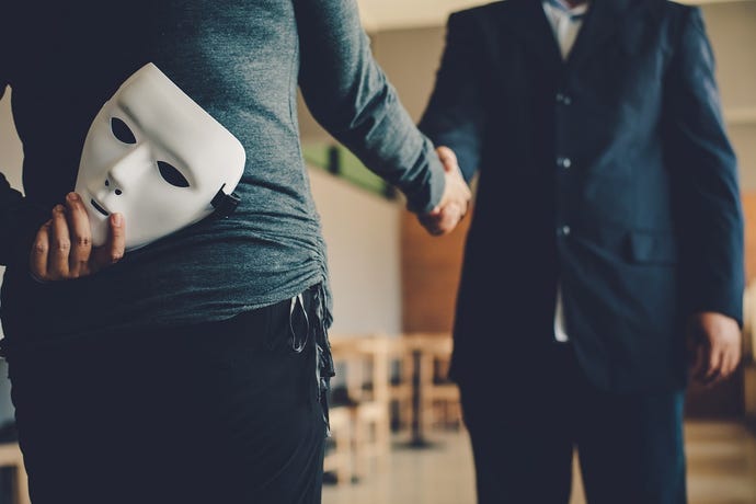 A woman holds a mask behind her back as she shakes hands with a businessman