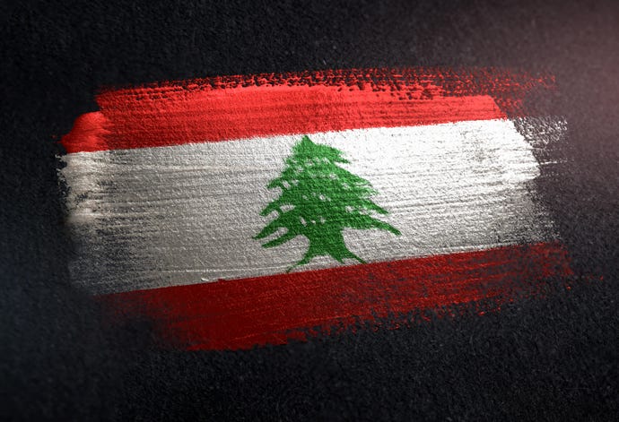Image of Lebanon flag. It has two horizontal red stripes enveloping a horizontal white stripe that contains a green cedar tree.