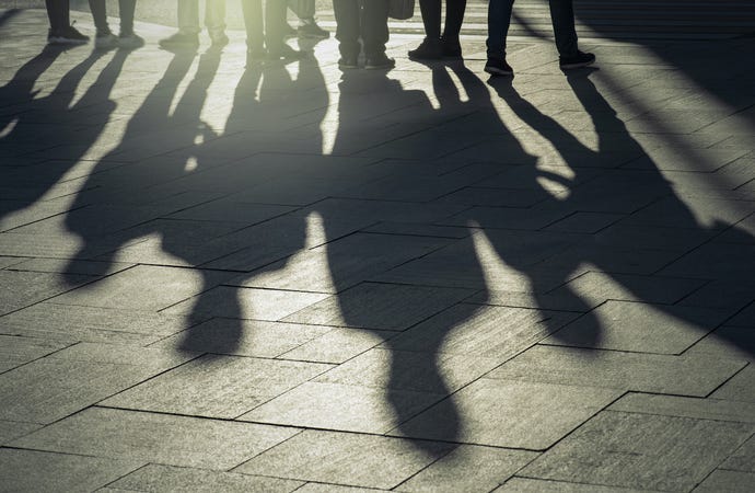 shadows of a group of people on city sidewalk