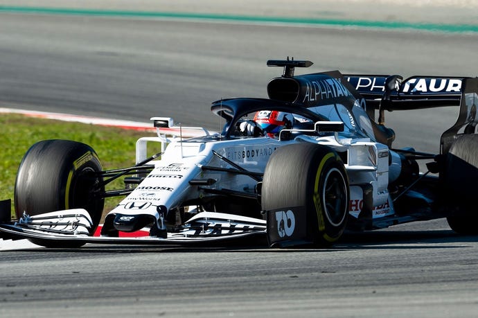 Alpha Tauri Formula One race car speeding around a corner on a race track