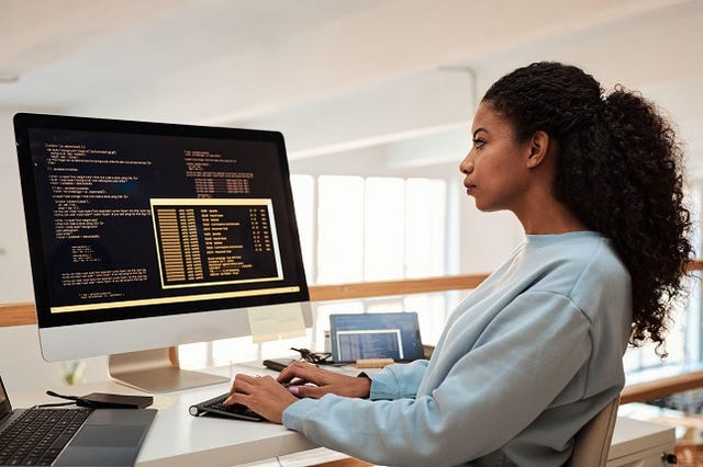 Young female software engineer verifying and deploying programs and systems
