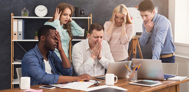 employees stand around computer