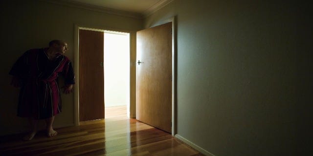 shadowy person creeping through a hallway
