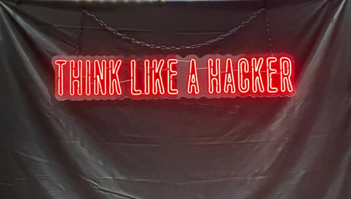 Signage that reads "think like a hacker" from DEF CON 30 IoT Village
