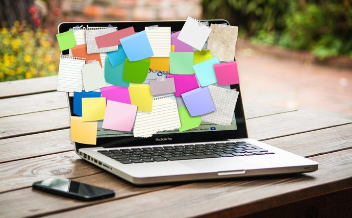 Laptop with Post-it notes all over it