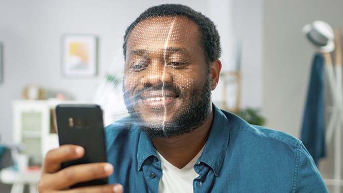 Futuristic Concept of a Young Man Identified by Biometric Facial Recognition Scanning Process from His Smartphone.