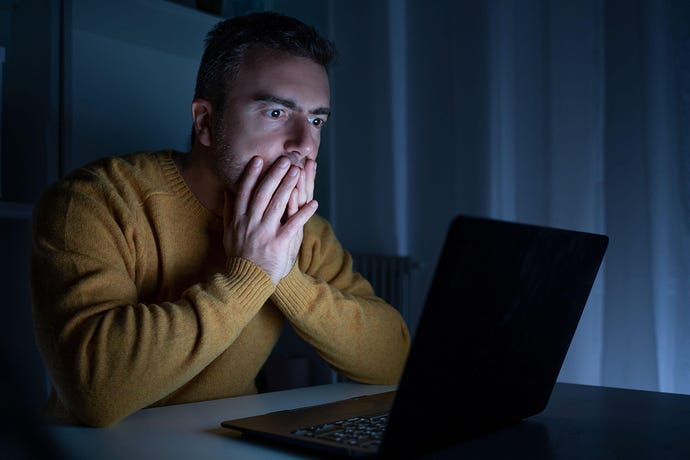 Photo of shocked man reading bad news on laptop