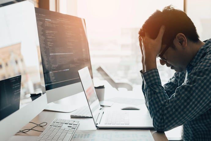 Image of frustrated man looking at his laptop screen.