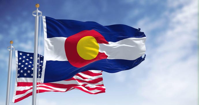 The Colorado state flag waving along with the national flag of the United States of America. 