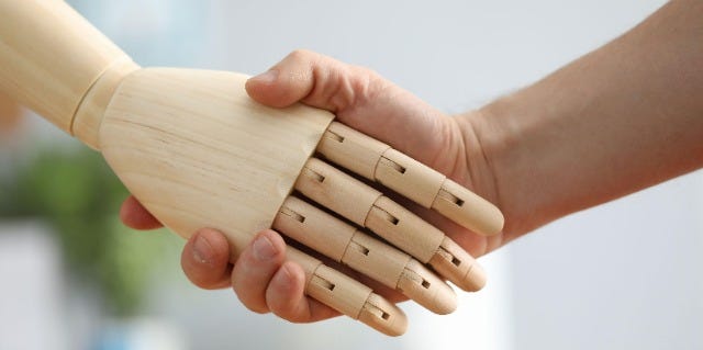 Artificial hand shaking a human hand