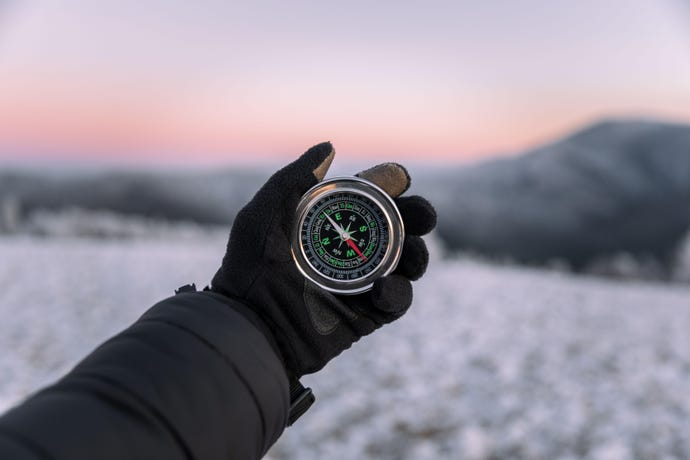 hand holding compass to illustrate wilderness survival 