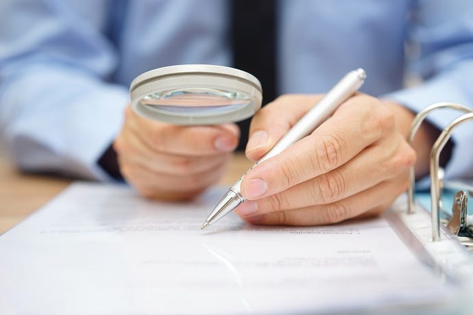 Person reading something closely with a magnifying glass