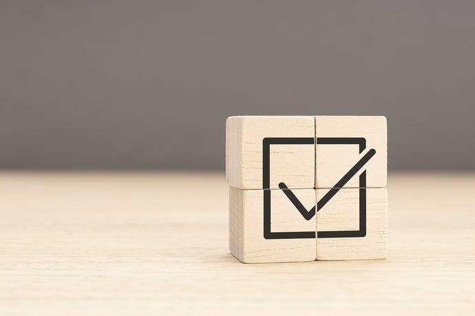 A checkmark on four wooden blocks