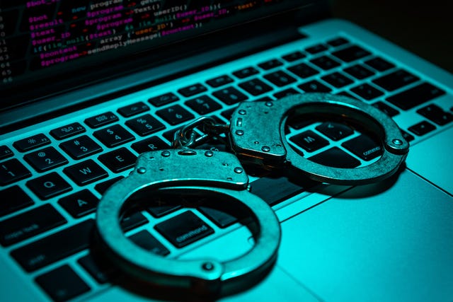 Handcuffs sit on a computer keyboard
