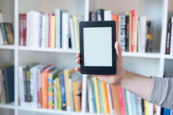 e-reader displayed in front of colorful bookshelf