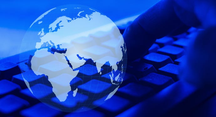 Hand on a keyboard overlayed with the image of the world, with a blue filter.