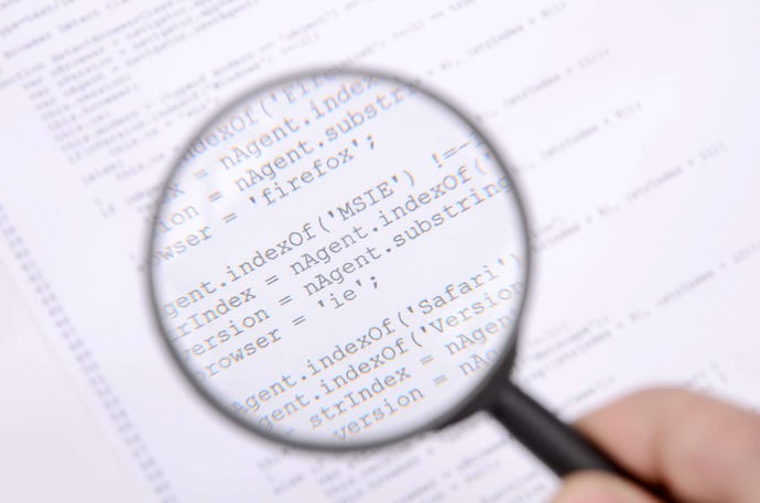 A hand holds a magnifying glass over a page of Java code