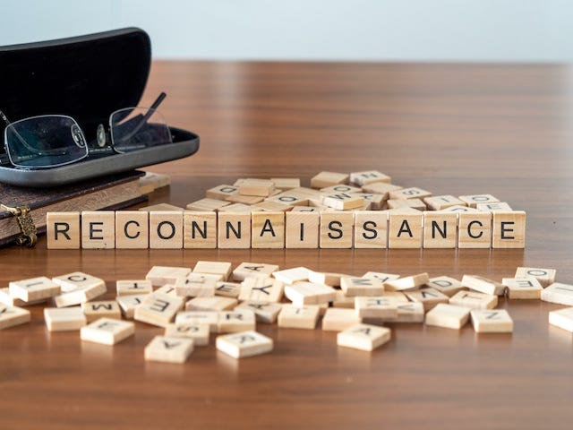 Scrabble tiles spelling out the word 'reconniassance' on a table.