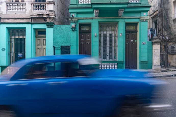 old blue car speeding along in Havana