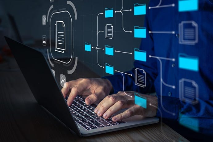 Document Management System (DMS) being setup by IT consultant working on laptop computer in office.