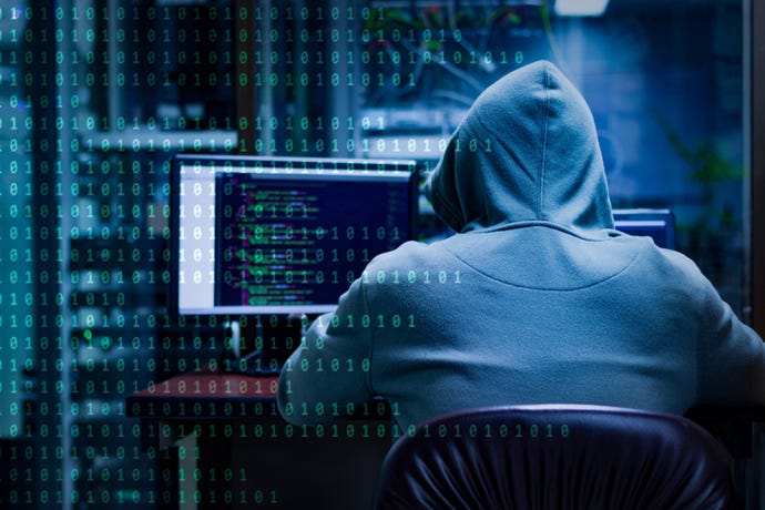 Concept image showing hooded hacker sitting at a computer