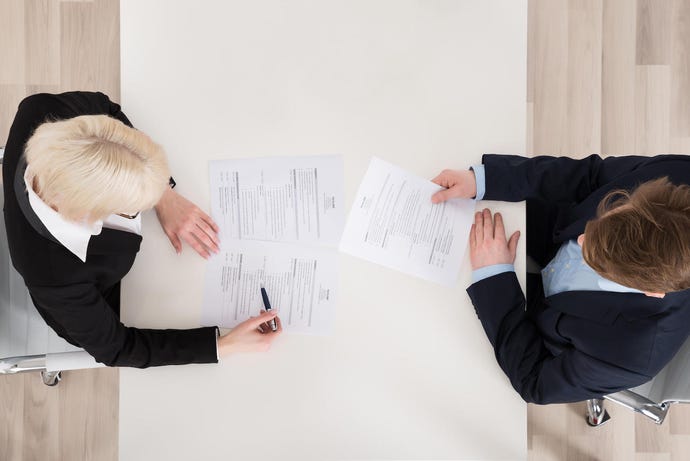 Two recruiters reviewing resumes hiring