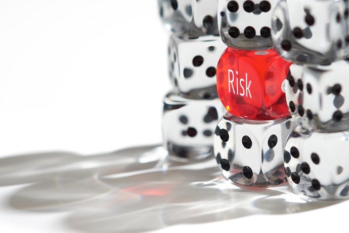 Die with the word Risk on it among regular dice