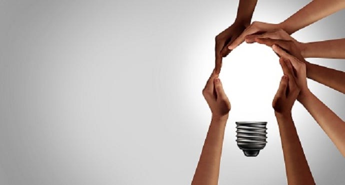 diverse hands surrounding a lightbulb