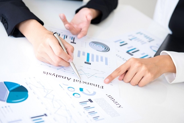 Business people discussing and analyzing documents at meeting table