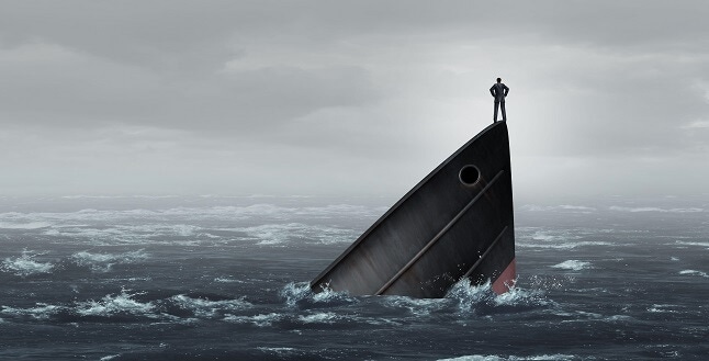 ship sinking with businessperson standing on bow