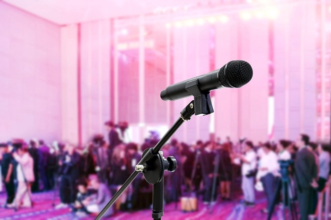 scene of a conference with microphone in foreground