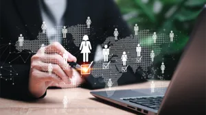 A business women at a laptop makes checks off a box on an overlay of an org chart A business women at a laptop makes checks off a box on an overlay of an org chart