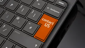 Laptop keyboard with dark keys and an orange key reading 'Contact Us' Laptop keyboard with dark keys and an orange key reading 'Contact Us'