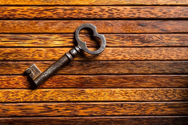 old key lies on an old wooden table, natural textures, the concept of discoveries, secrets, answers