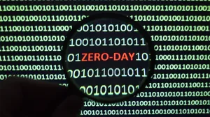 An IT professional holds a magnifying glass over a screen to illuminate the words 'zero-day' An IT professional holds a magnifying glass over a screen to illuminate the words 'zero-day'