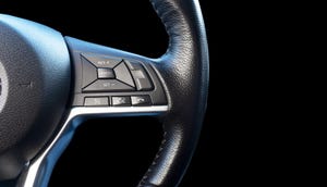 Part of modern steering wheel isolated on black background.